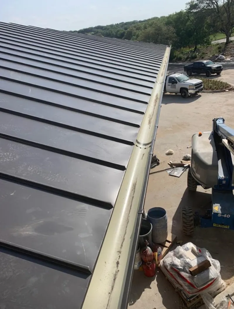Standing seam panel and gutter detail on a metal roofing jobsite in Auburn